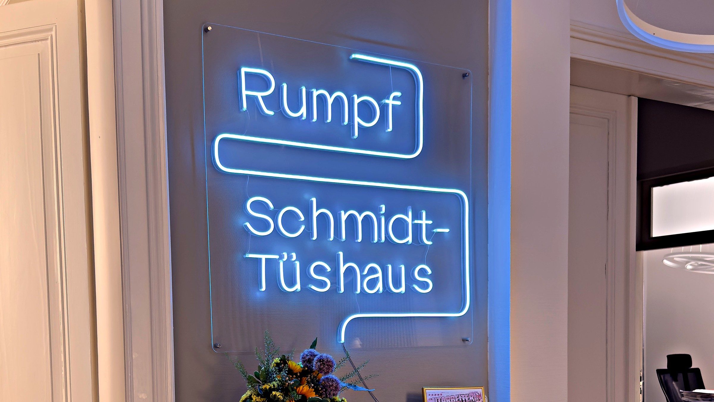 Empfang der Kanzlei mit dem beleuchteten Schriftzug Rumpf und Schmidt-Tüshaus